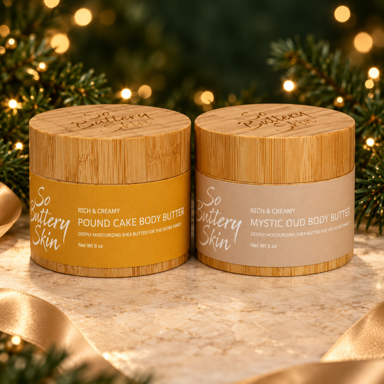 Luxe Holiday Oud Collection: Pound Cake and Mystic Oud Body Butter jars with holiday lights