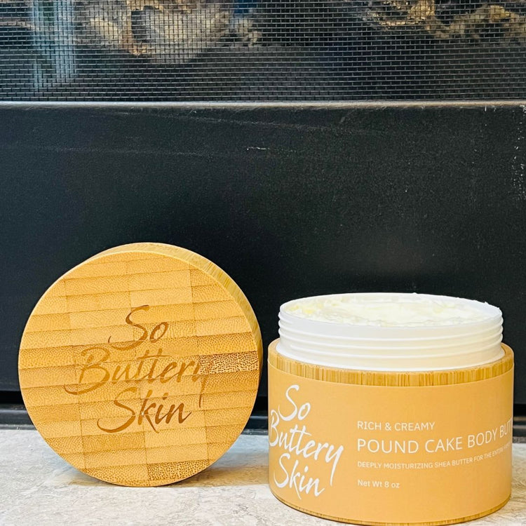 Hand scooping body butter from jar onto dry skin