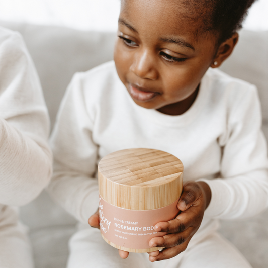 Little girl holding Jar of plant-based rosemary body butter