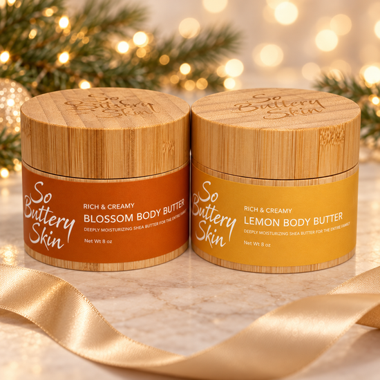 Holiday Glow Duo: Blossom and Lemon Body Butter jars with gold ribbon and holiday lights